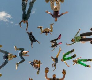 Grupo de personas saltando juntas en un acto de alegría y energía colectiva, simbolizando la unidad y el espíritu comunitario en los eventos y retiros espirituales de Oito en Barcelona.